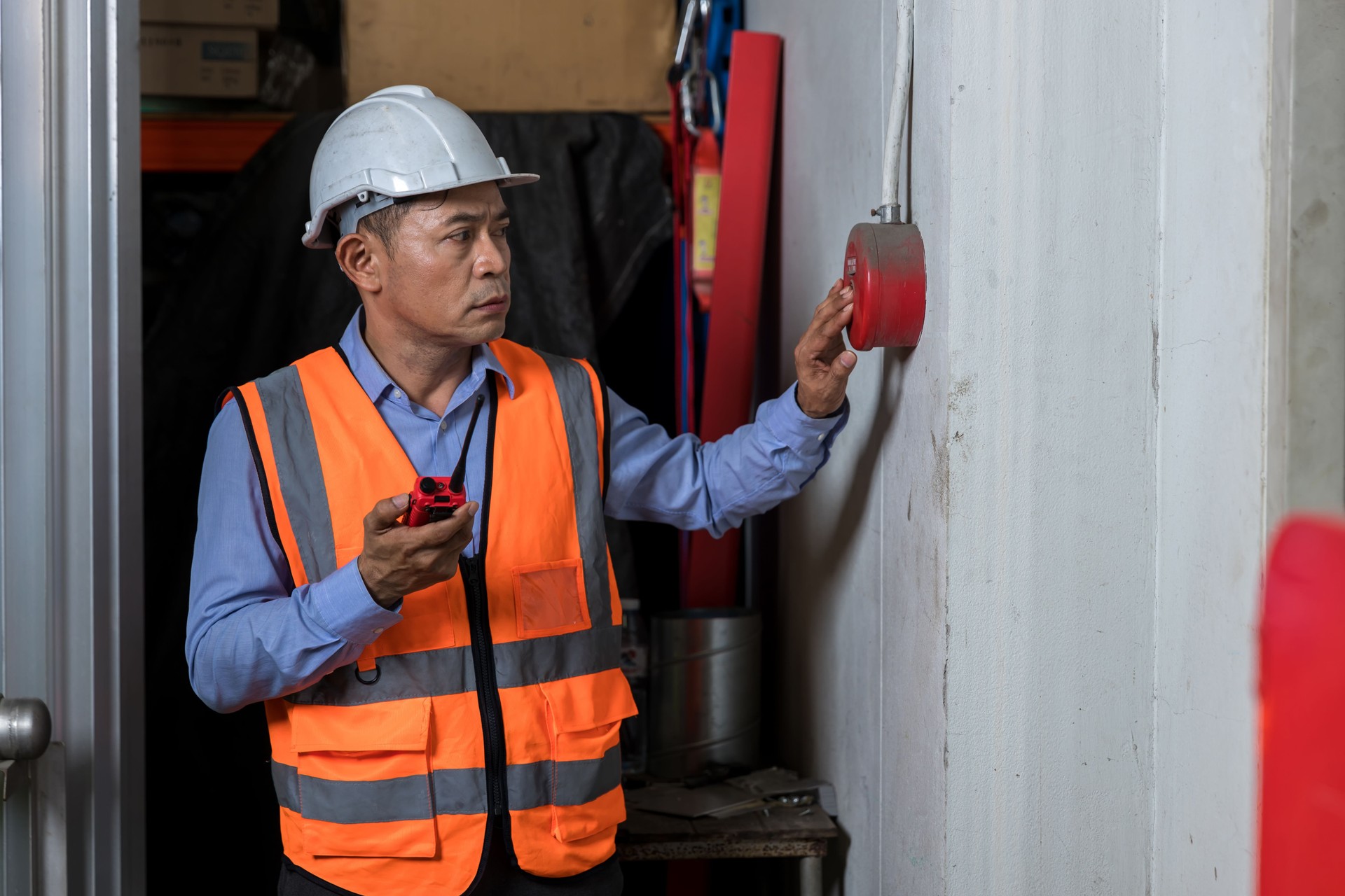 Foreman or worker pushing fire alarm on the wall. A fire! or Emergency case at the factory building. Emergency of Fire alarm or alert or bell warning equipment